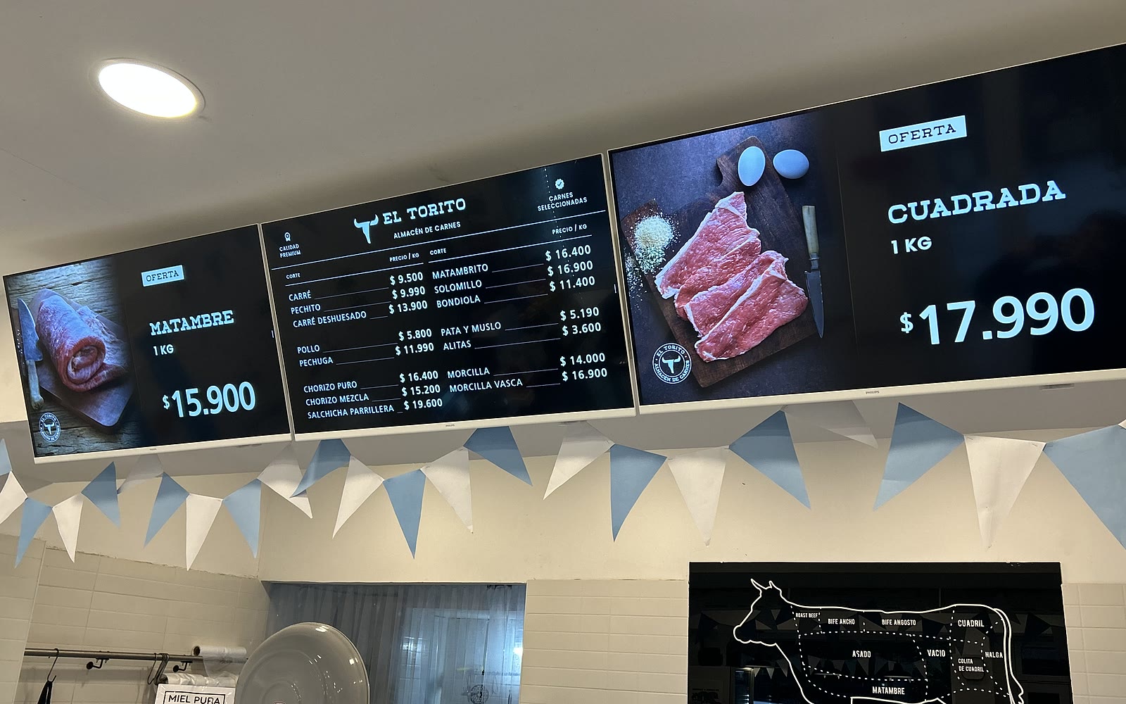 Cartelería digital de Vulsar mostrando listas de precios y promociones en las pantallas de un local